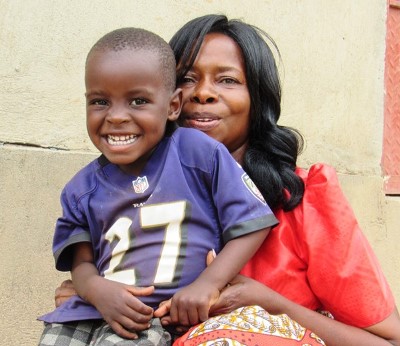 smiling Ugandan boy with foster mother