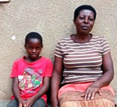Ugandan boy sitting by mother