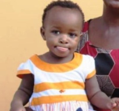 young Ugandan girl in orange and white striped dress