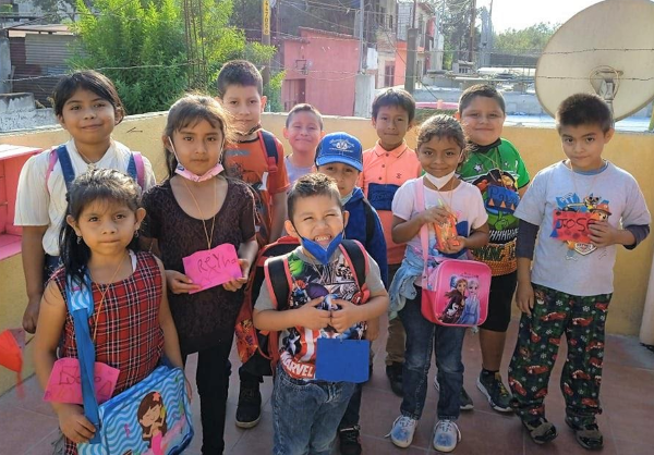 Children in Guatemala holding backpacks