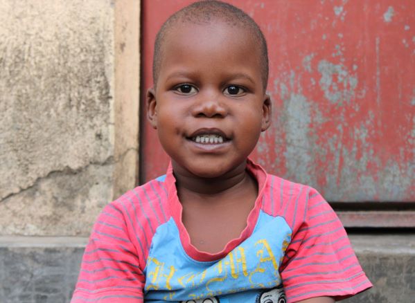 Boy in Uganda with red background