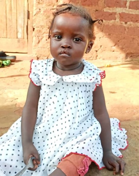 Uganda girl in white polka dot dress with ruffles