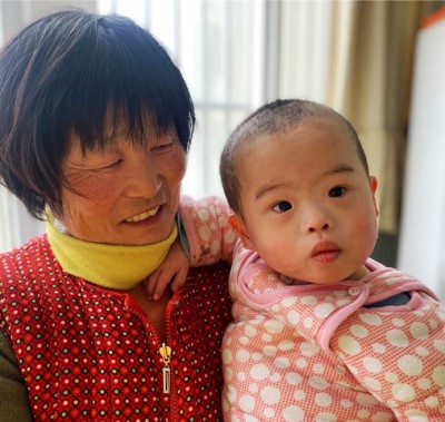 young child in China being held by woman