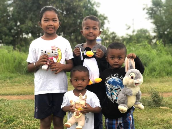 Sister and three little brothers holding stuffed animals
