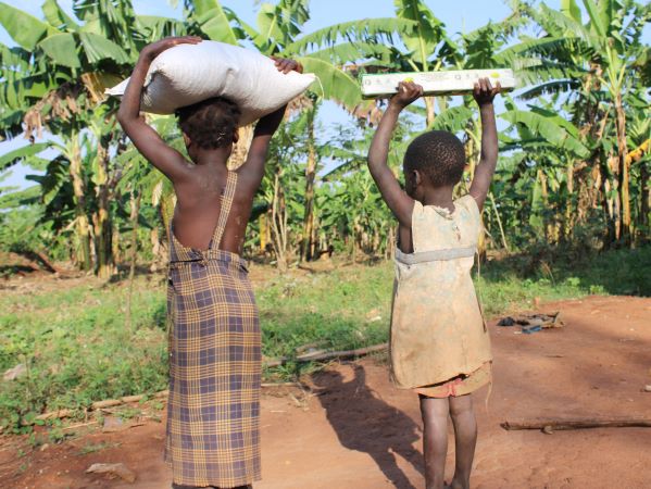 Two girls carrying food on their heads in Uganda