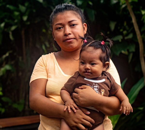 Mom in yellow shirt holding baby girl in Guatemala