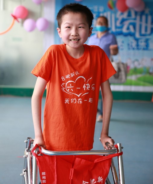 Boy smiling using a walker
