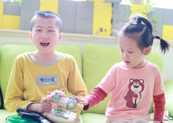 Boy and Girl in China playing with a toy