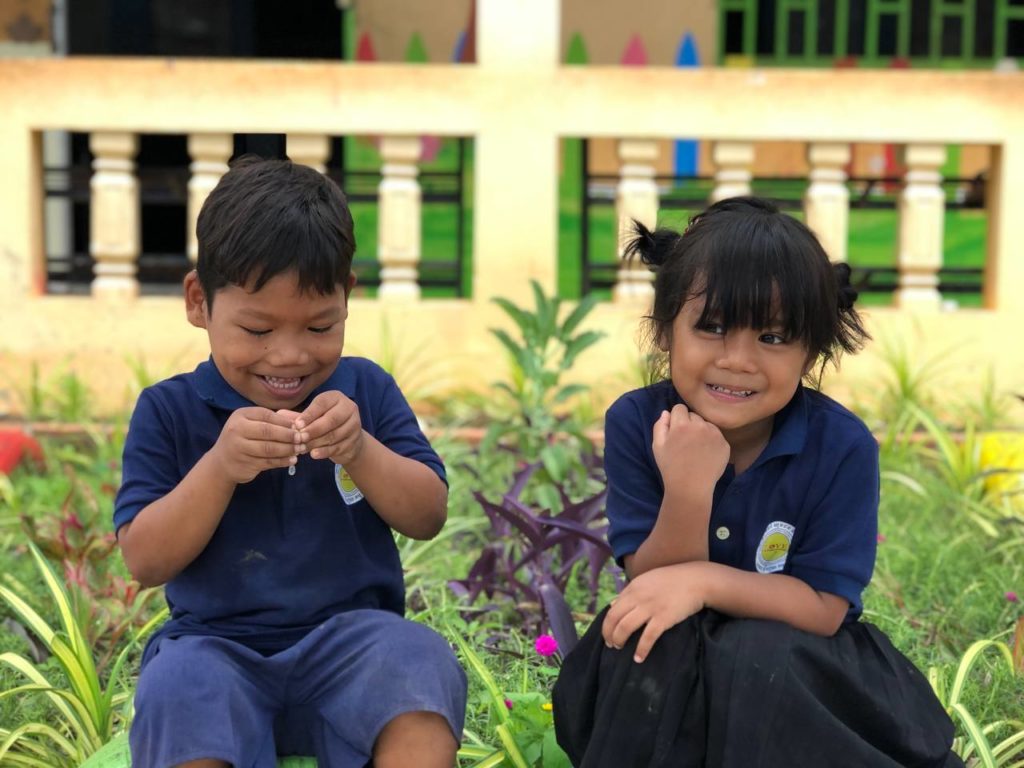 Two Cambodian preschool children sitting side by side