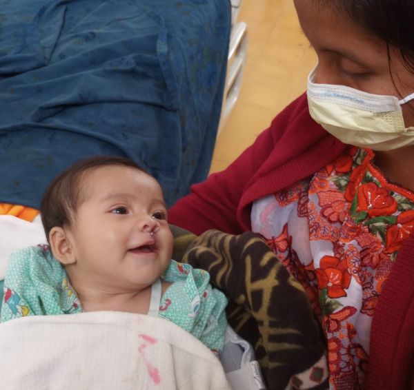Mom gazes at her son after cleft repair surgery