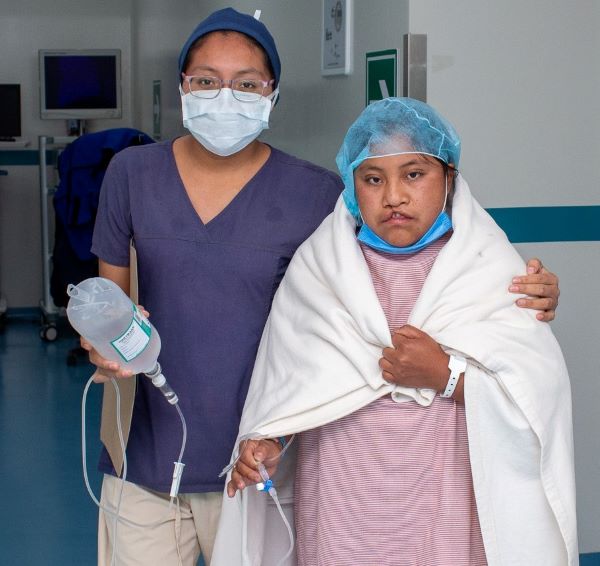 Nurse and patient with cleft walking to the OR