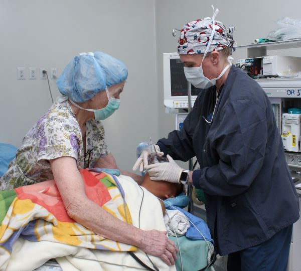 Anesthesiologists preparing a patient for cleft surgery