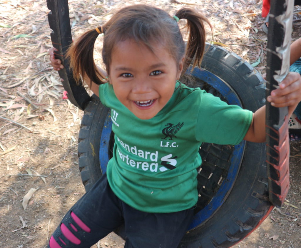 Cambodian girl on a tire swing
