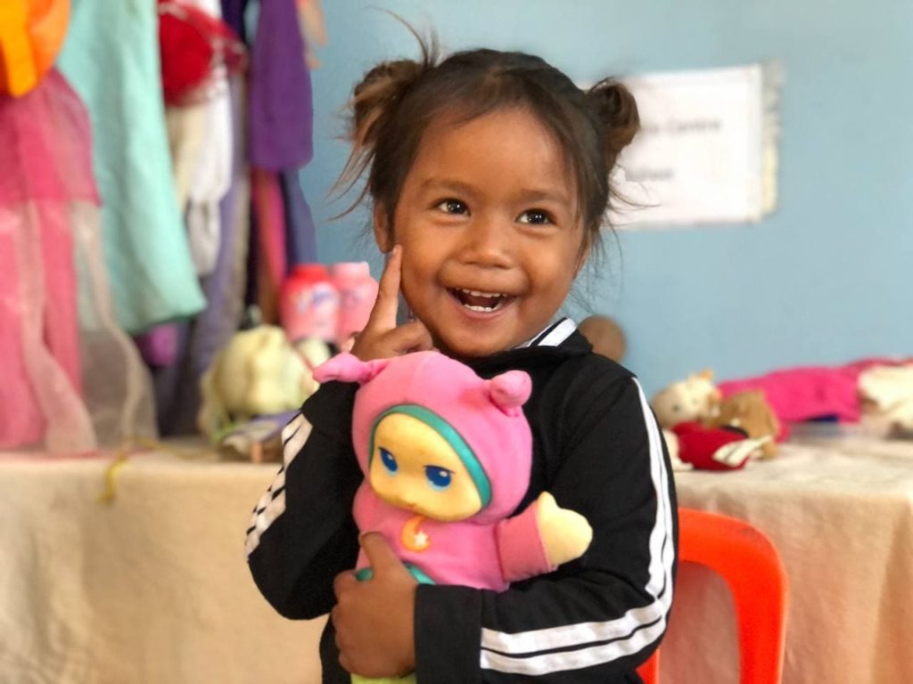 Cambodian girl in preschool holding a doll