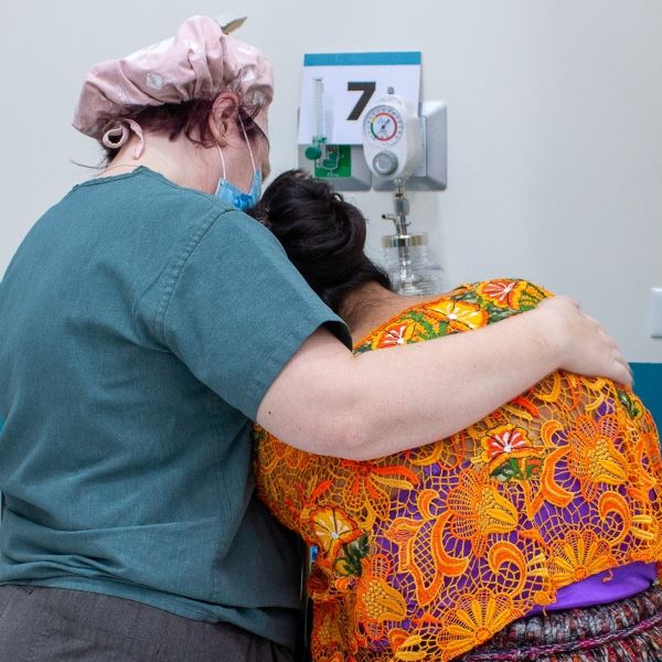 Nurse giving crying mom a shoulder to lean on