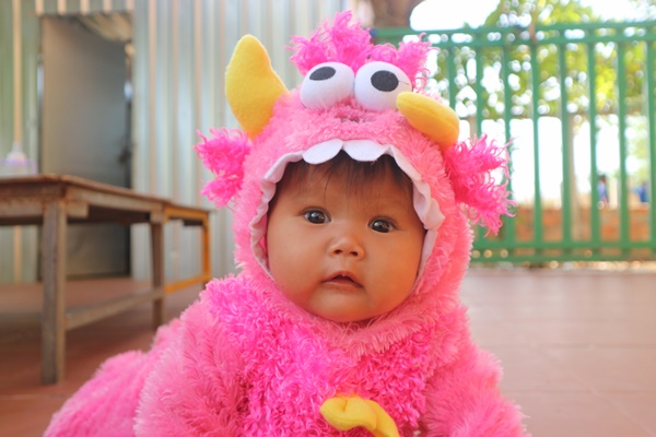 young girl in Cambodia wearing pink muppet costume