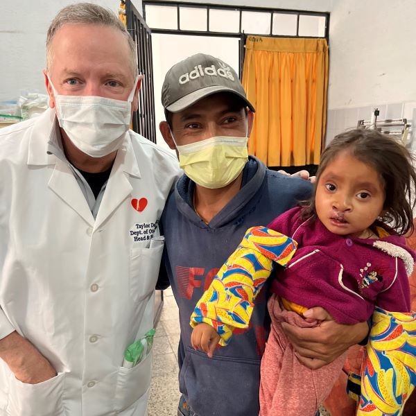 Girl and her father with doctor after cleft repair surgery