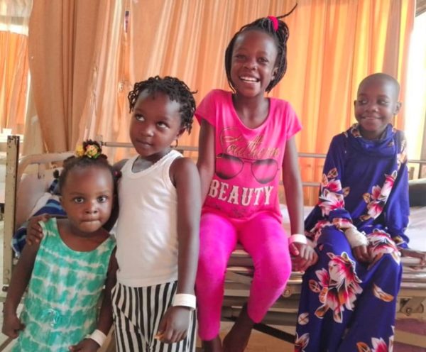 Four Ugandan girls sitting together in a hospital