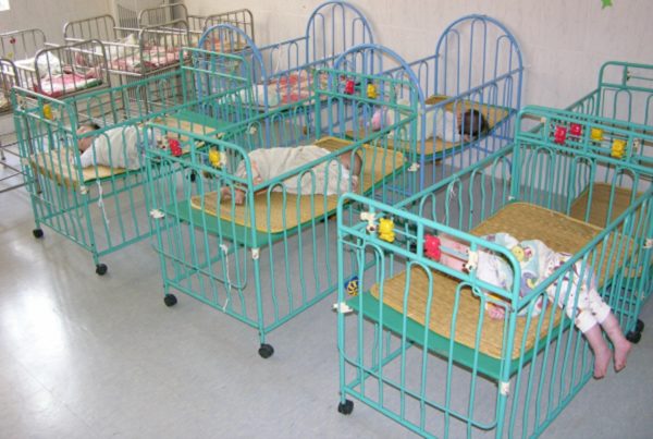 Babies in metal cribs in a Chinese orphanage