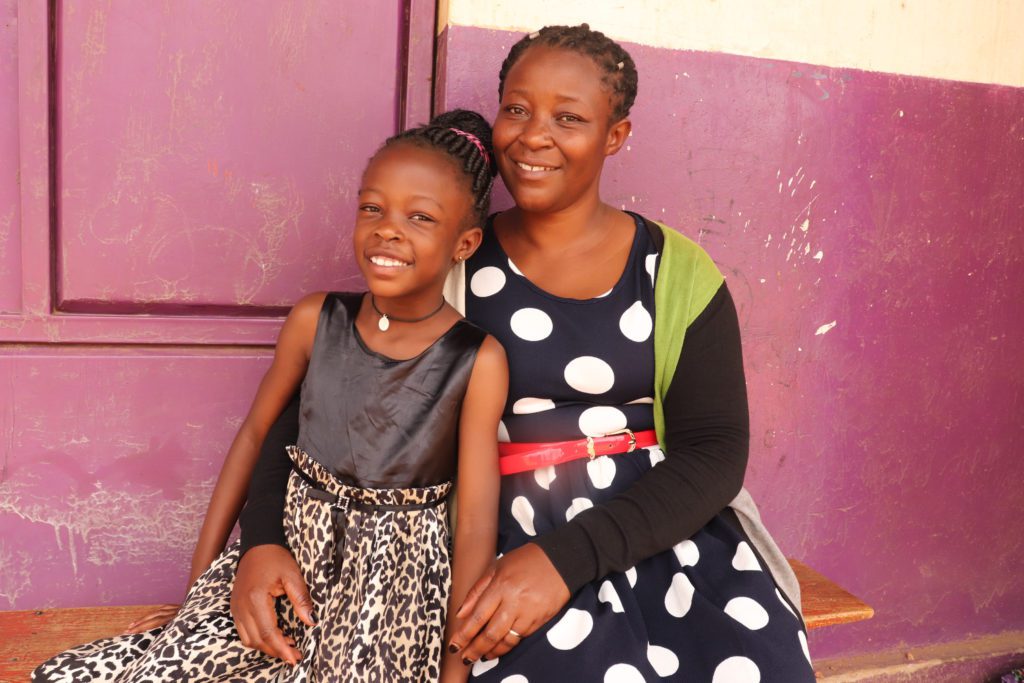 Ugandan mother and daughter sitting together and smiling