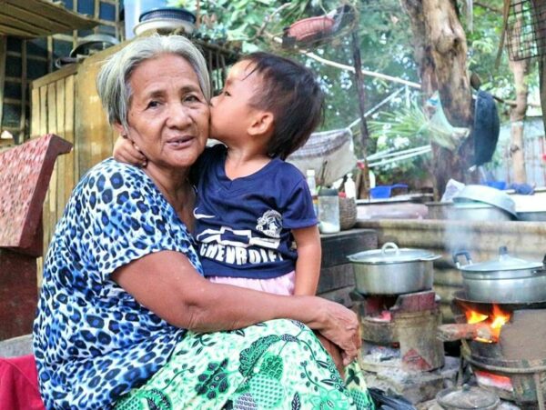 Little boy kissing foster grandma in Cambodia