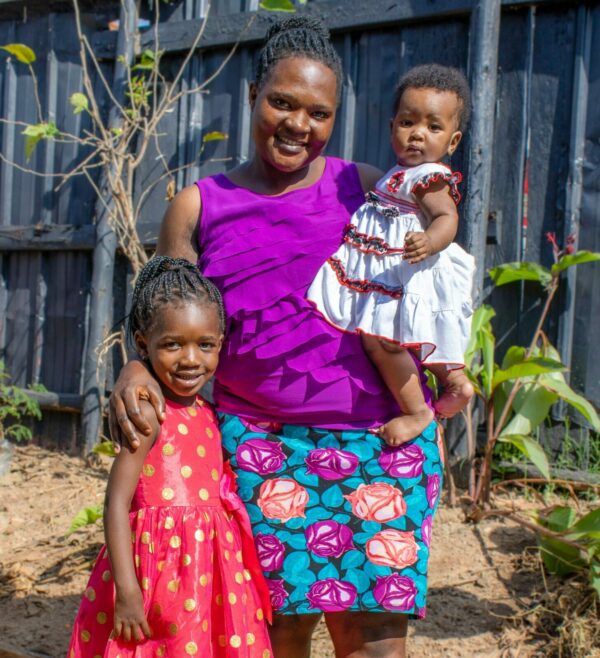Ugandan girl with her mom and baby sister
