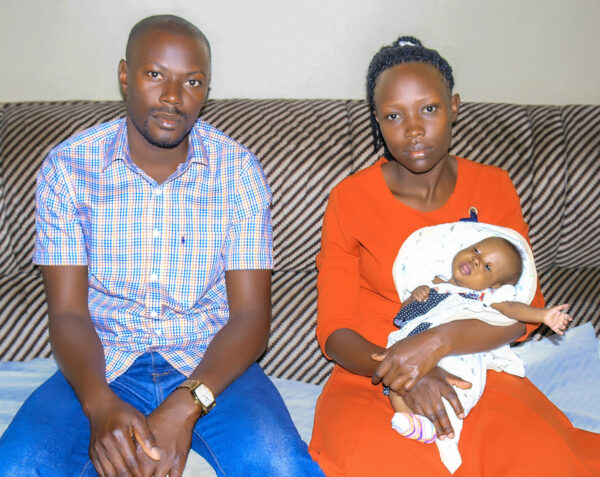 Uganda parents holding baby girl