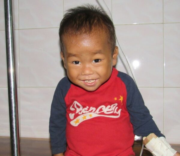 Cambodian boy in hospital smiling with an IV