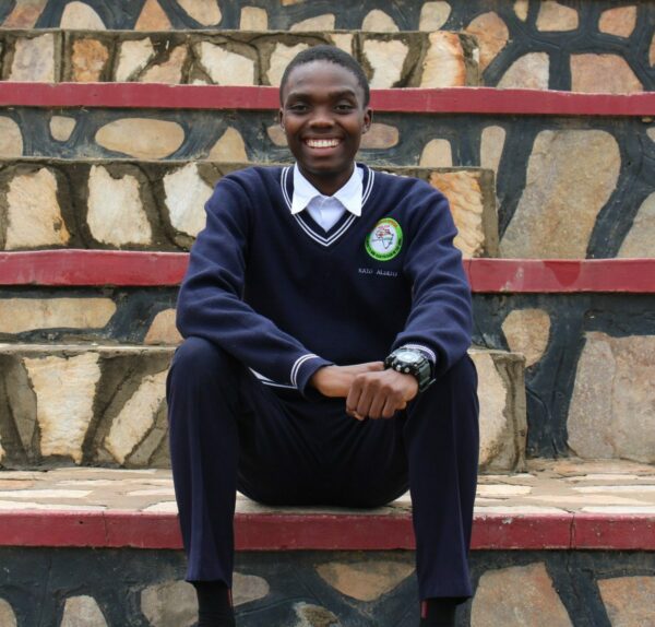 Teen boy sitting on steps in school uniform