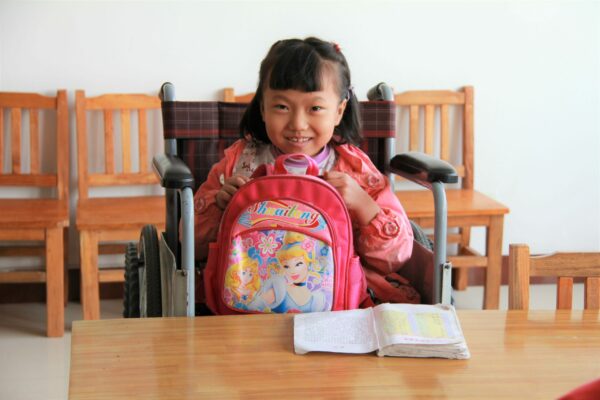 Little girl sitting in a wheelchair in an orphanage illustrating Stories of Hope