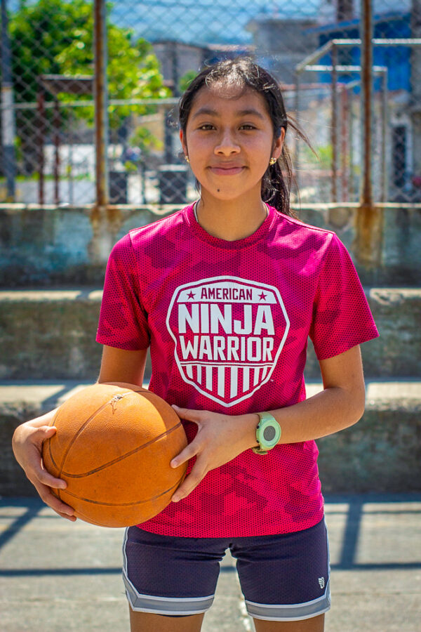 Girl in pink shirt holding a basketball