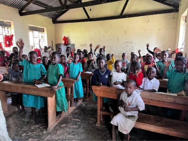 Crowded Uganda school with children waving