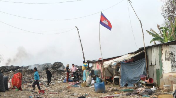 Shacks at a Cambodian landfill with people outside