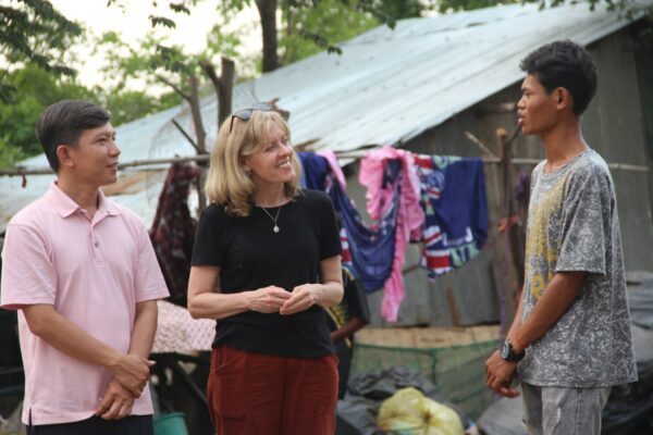 Two adults talking with teen boy in Cambodia