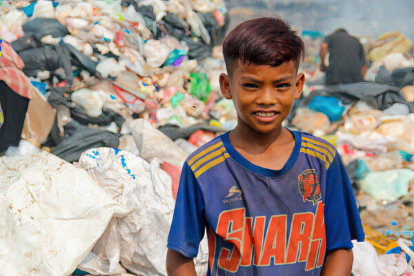 Boy in blue soccer shirt at landfill