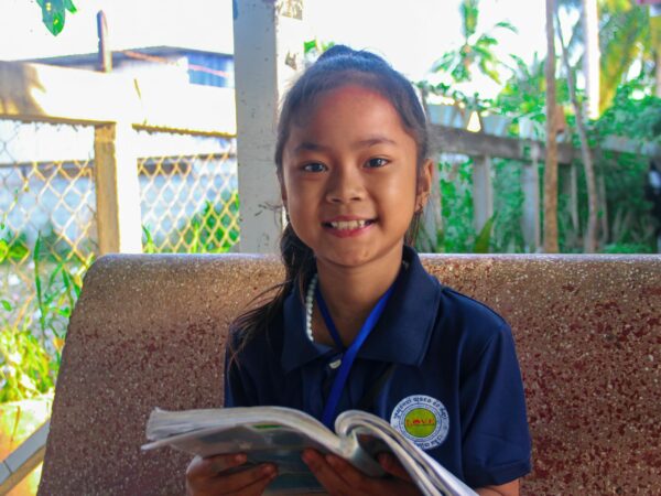 Girl in blue school uniform reading a book
