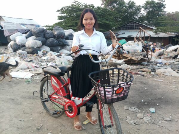 Girl with bike at landfill