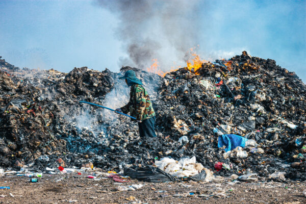 Man going through trash at a Cambodian landfill