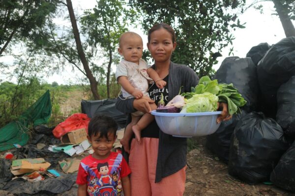 Mom with two children and basket of produce at landfill