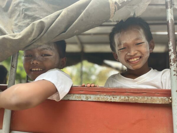 Boys in tuk tuk with powder on faces