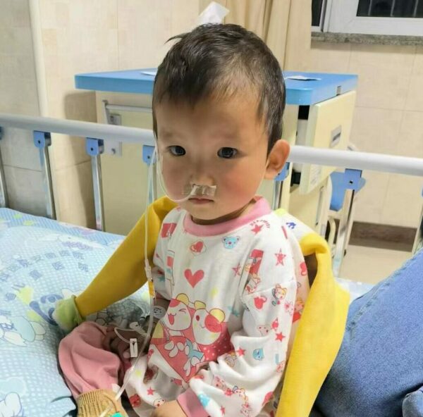 Toddler girl sitting in hospital bed