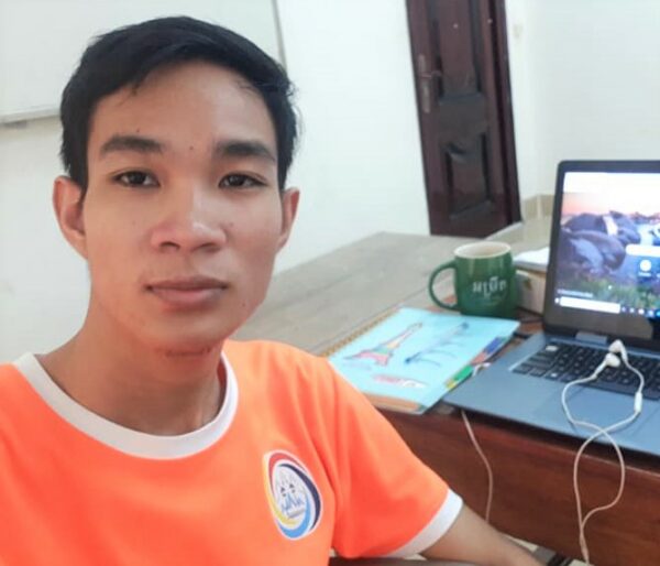 Boy in orange shirt in front of a computer