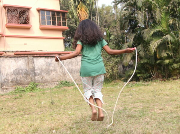 Barefoot girl jumping rope in India