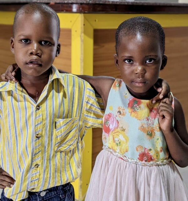 Ugandan boy and girl with arms around each other's shoulders