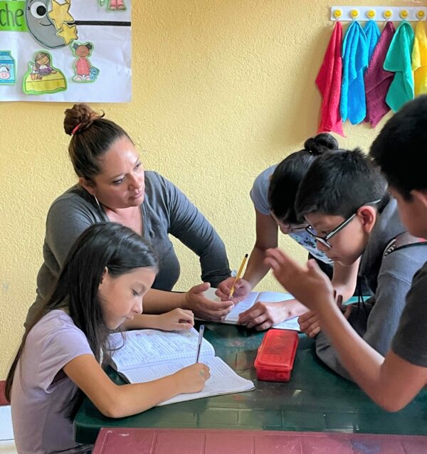 Children in Guatemalan school working with a tutor
