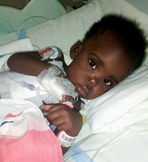 Toddler girl lying on side in hospital bed after surgery