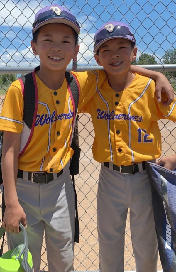 Twin boys in gold baseball uniforms at the ballfields