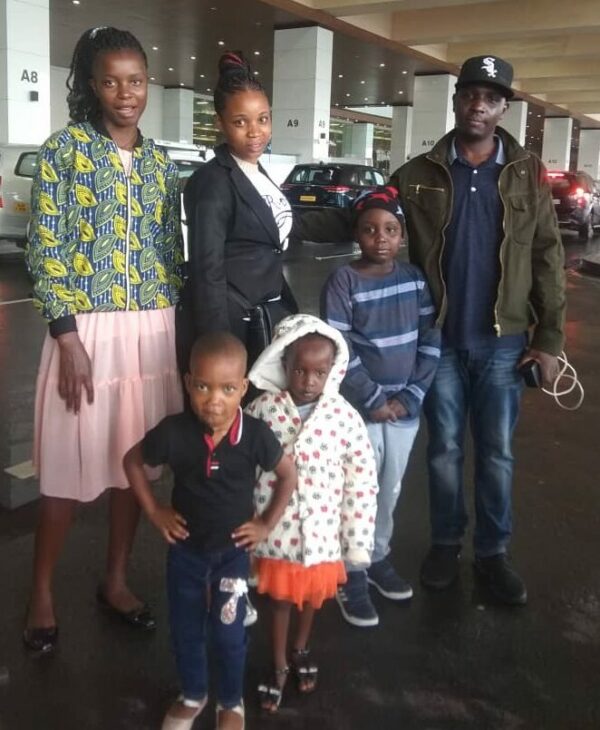 3 children and their parents from Uganda arrive at an Indian airport