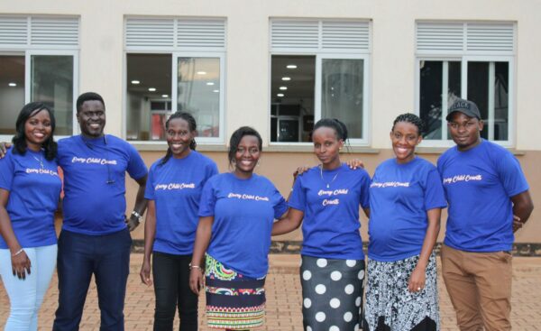 7 members of a Uganda hernia medical mission team wearing blue shirts that say Every Child Counts