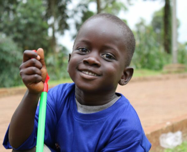 Ugandan boy in a blue shirt waiting for hernia surgery